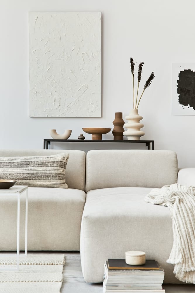 Living room with a picture on the wall, vases and a large white sofa